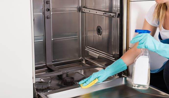 A person cleaning an appliance with equipment