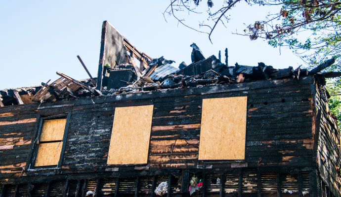 Boarded up fire damaged house