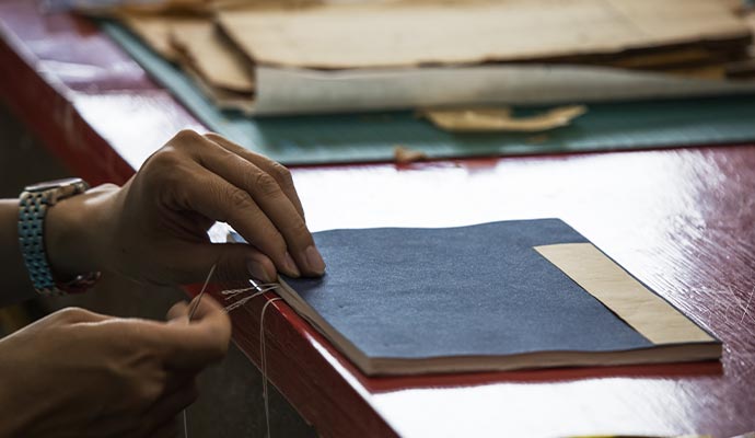 Person sewing a book