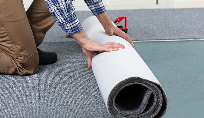 a person replacing carpet